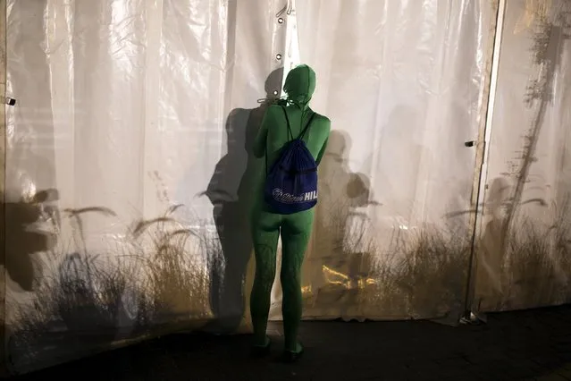 A woman, wearing her full solid-coloured bodysuit prepares before taking part in a street art performance in Bat Yam, near Tel Aviv, Israel August 29, 2015. (Photo by Amir Cohen/Reuters)