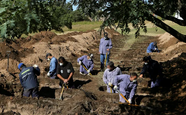 Gravediggers open new graves at the San Vicente cemetery, during the coronavirus disease (COVID-19) spread, in Cordoba, Argentina on April 13, 2020. (Photo by Sebastian Salguero/Reuters)