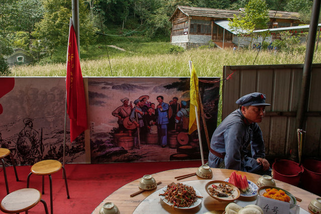 A participant dressed in replica red army uniform waits for lunch during a Communist team-building course extolling the spirit of the Long March, organised by the Revolutionary Tradition College, in the mountains outside Jinggangshan, Jiangxi province, China, September 14, 2017. (Photo by Thomas Peter/Reuters)