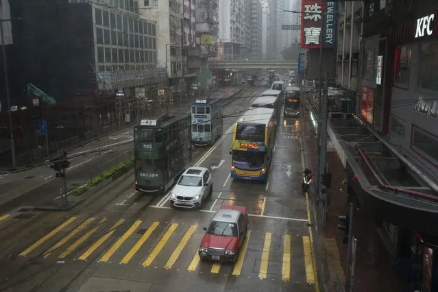Vehicles drive past an intersection in the Causeway Bay area as tropical storm Ma-on passes Hong Kong, Thursday, August 25, 2022. (Photo by Anthony Kwan/AP Photo)