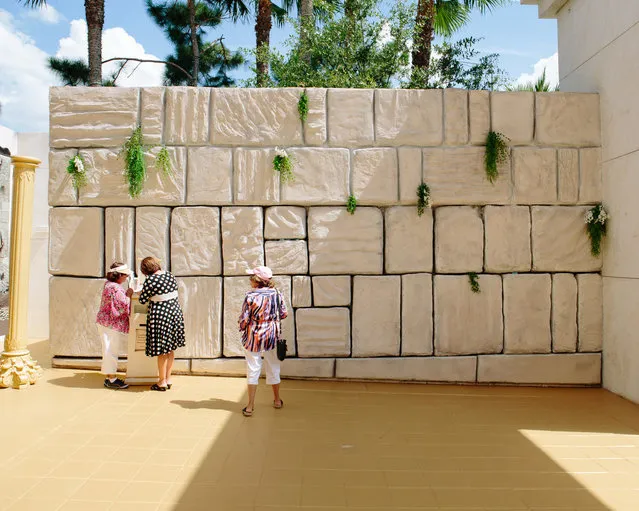 Women write down prayers and put them in the cracks of a replica Wailing Wall at The Holy Land Experience. (Photo by Daniel Cronin)