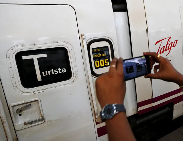 A man takes pictures of the high speed Talgo train during its trial run at a railway station in Mumbai, India August 2, 2016. (Photo by Danish Ismail/Reuters)