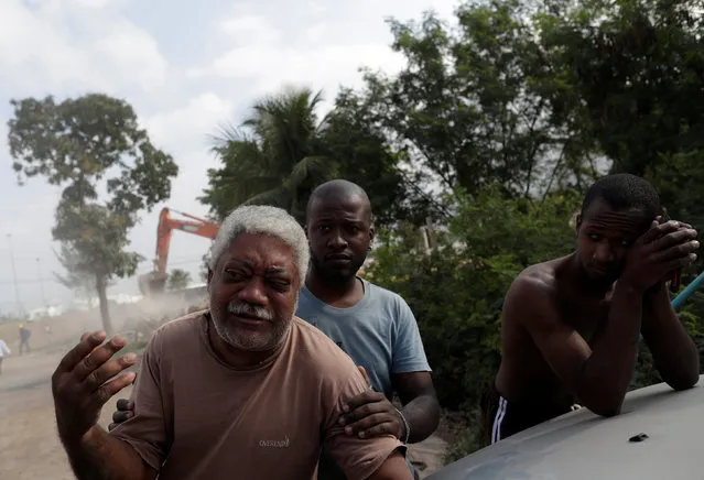 Carlos Augusto (L),  who has lived in the Vila Autodromo slum for 20 years, reacts as his house is being demolished after he moved to one of the twenty houses built for the residents who refused to leave the community, in Rio de Janeiro, Brazil, August 2, 2016. (Photo by Ricardo Moraes/Reuters)