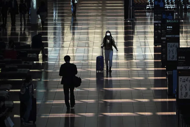 In this April 29, 2020, file photo, a few passengers walk at a domestic terminal of Haneda Airport in Tokyo, at the start of “Golden Week” holidays. Under Japan's coronavirus state of emergency, people have been asked to stay home. Many are not. Some still have to commute to their jobs despite risks of infection, while others are dining out, picnicking in parks and crowding into grocery stores with scant regard for social distancing. (Photo by Eugene Hoshiko/AP Photo)