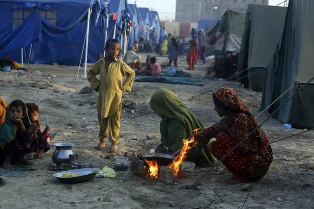 Victims of heavy flooding from monsoon rains take refuge as they prepare tea at a temporary tent housing camp organized by the UN Refugee Agency (UNHCR), in Sukkur, Pakistan, Saturday, September 10, 2022. Months of heavy monsoon rains and flooding have killed over a 1000 people and affected 3.3 million in this South Asian nation while half a million people have become homeless. (Photo by Fareed Khan/AP Photo)