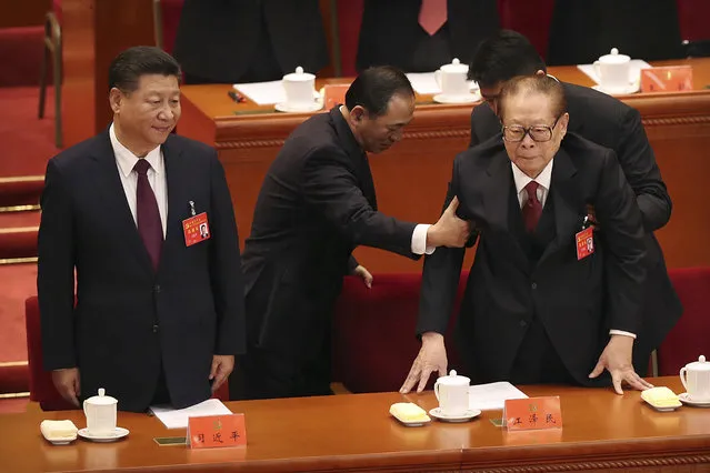 Chinese President Xi Jinping, left, stands as staff help former Chinese President Jiang Zemin during the opening session of China's 19th Party Congress at the Great Hall of the People in Beijing, Wednesday, October 18, 2017. Xi on Wednesday urged a reinvigorated Communist Party to take on a more forceful role in society and economic development to better address “grim” challenges facing the country as he opened a twice-a-decade national congress. (Photo by Mark Schiefelbein/AP Photo)