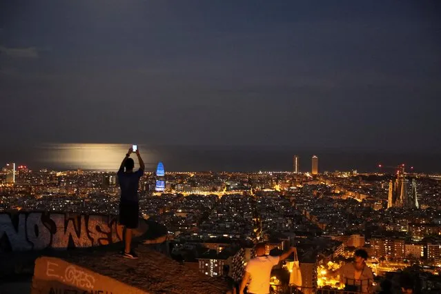 A man wearing a protective mask takes a picture of the city of Barcelona, as the spread of the coronavirus disease (COVID-19) continues, in Barcelona, Spain on May 6, 2020. (Photo by Nacho Doce/Reuters)