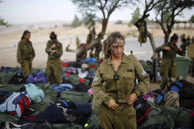 An Israeli soldier of the Caracal battalion stands next to backpacks after finishing a march May 29, 2014. (Photo by Amir Cohen/Reuters)