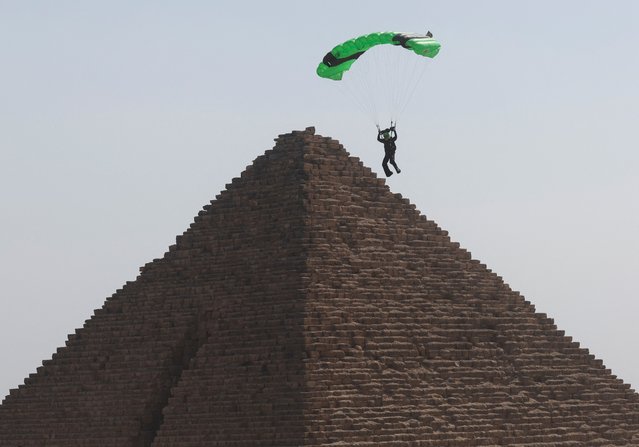 A professional skydiver flies over the historical site of Giza Pyramids, as they fly over the Pyramid of Menkaure during Egypt International Skydiving Festival ”Jump Like a Pharaoh”, in Giza, Egypt on October 29, 2024. (Photo by Amr Abdallah Dalsh/Reuters)