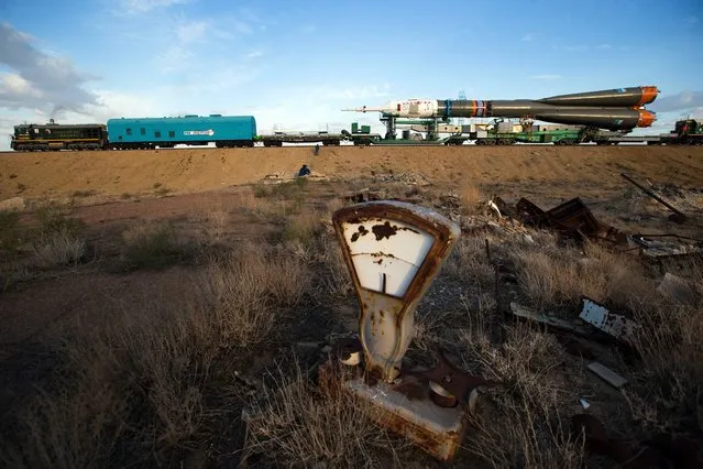 An old tossed out scales is scattered in a field as Russia's Soyuz-FG booster rocket with the space capsule Soyuz TMA-14M that will carry a new crew to the International Space Station (ISS) is transported from hangar to the launch pad at the Russian leased Baikonur Cosmodrome, Kazakhstan, Tuesday, September 23, 2014. (Photo by Pavel Golovkin/AP Photo)