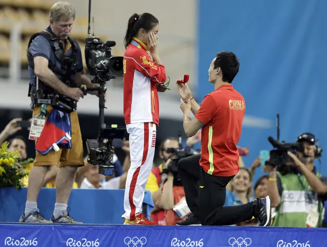 China's silver medalist He Zi, left, receivers a marriage proposal by China's diver Qin Ki, right, during the medal ceremony for the the women's 3-meter springboard diving final in the Maria Lenk Aquatic Center at the 2016 Summer Olympics in Rio de Janeiro, Brazil, Sunday, August 14, 2016. (Photo by Michael Sohn/AP Photo)