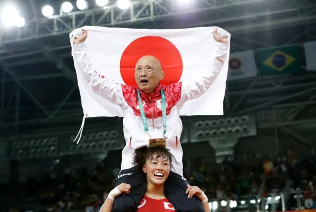 Japan's Eri Tosaka celebrates with her coach winning against Azerbaijan's Mariya Stadnyk in their women's 48kg freestyle final match on August 17, 2016, during the wrestling event of the Rio 2016 Olympic Games at the Carioca Arena 2 in Rio de Janeiro. (Photo by Jack Guez/AFP Photo)