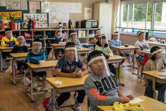 Children wearing plastic face visors sit in class at Kinugawa Elementary School on June 3, 2020 in Nikko, Japan. Schools in Japan reopened this week after being forced to close earlier in the year by the Covid-19 coronavirus outbreak. Safety measures have been implemented throughout the country, including social distancing in classrooms, use of hand sanitiser, face masks and, in some cases, plastic face visors for students and teachers. (Photo by Carl Court/Getty Images)