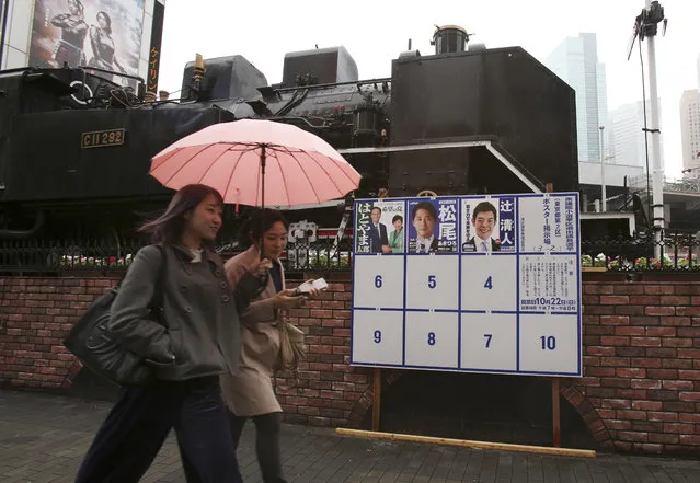 People walk past campaign posters for the upcoming lower house election in Tokyo, Saturday, October 14, 2017. The election is scheduled for Oct. 22, with Japanese Prime Minister Shinzo Abe's ruling party facing challenges from regrouped opposition forces. (Photo by Koji Sasahara/AP Photo)