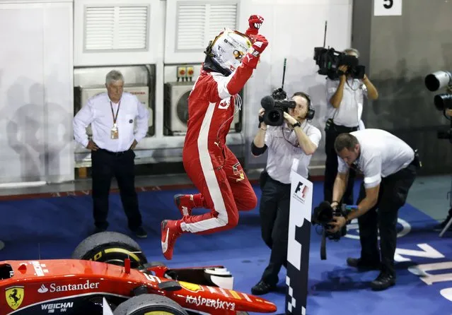 Ferrari Formula One driver Sebastian Vettel of Germany jumps off the front of his car after winning the Singapore F1 Grand Prix at the Marina Bay street circuit September 20, 2015. (Photo by Olivia Harris/Reuters)