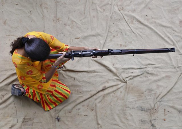 A girl practises with a rifle during weapons training course at the firing range of the police headquarters in Ahmedabad August 12, 2014. (Photo by Amit Dave/Reuters)