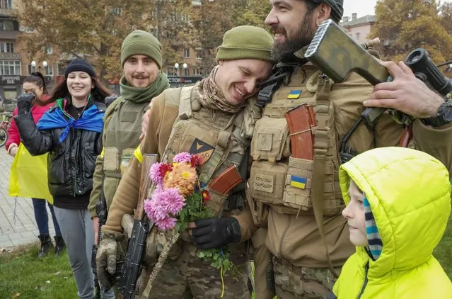 Local residents welcome Ukrainian servicemen as people celebrate after Russia's retreat from Kherson, in central Kherson, Ukraine on November 12, 2022. (Photo by Lesko Kromplitz/Reuters)