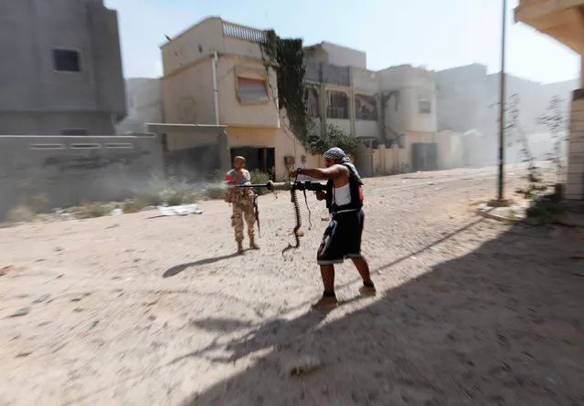 A member of Libyan forces allied with the UN-backed government fires a weapon towards Islamic State militants in neighbourhood Number One in central Sirte, Libya August 28, 2016. (Photo by Ismail Zitouny/Reuters)