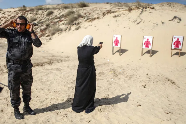 A Palestinian woman fires at a target during a training session for the families of Hamas officials, organized by Hamas-run Security and Protection Service, in Khan Younis in the southern Gaza Strip July 24, 2016. (Photo by Xinhua/Barcroft Images)