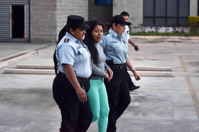 Theodora of Carmen Vasquez (C) is escorted at the end of the hearing held to review her 2008 sentence – handed down under a draconian anti- abortion law after she suffered a miscarriage – in San Salvador on December 13, 2017. Salvadorean justice reviewed on Wednesday the 30- year prison term handed to Vasquez after she was found guilty of “aggravated homicide” for a stillbirth in her ninth month of pregnancy. Her lawyer and rights groups are calling for her to be freed. (Photo by Oscar Rivera/AFP Photo)