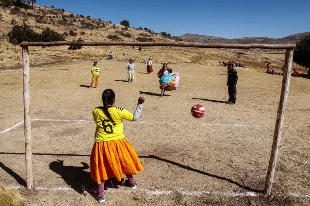 Aymara indigenous women play soccer during a championship in the Aymara district of Juli in Puno, southern Peru, on July 16, 2022. (Photo by Carlos Mamani/AFP Photo)
