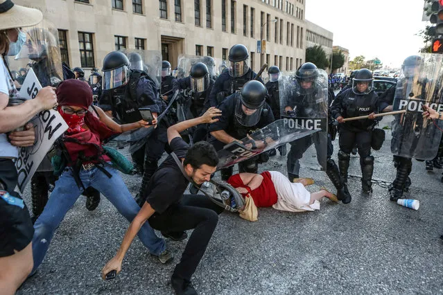 Protesters fall as they are pushed back by police in riot gear during a protest after a not-guilty verdict in the murder trial of former St. Louis police officer Jason Stockley, charged with the 2011 shooting of Anthony Lamar Smith, who was black, in St. Louis, Missouri, September 15, 2017. (Photo by Lawrence Bryant/Reuters)