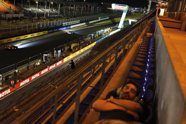 A fan sleeps in the stands during the 24-hour Le Mans endurance race, Sunday, June 15, 2025 in Le Mans, western France. (Photo by Jeremias Gonzalez/AP Photo)