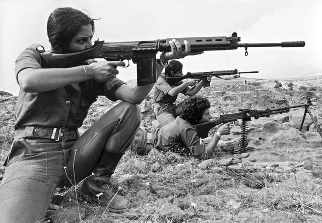 Young Christian Lebanese women, who are members of Kataeb Phalangist party, show their skill in handling arms while they train in a village between Christian-controlled eastern port of Jounieh and the Christian village of Zahle in the west Lebanon on September 9, 1976. The Lebanese civil war erupted in April 1975. (Photo by Erich Stering/AFP Photo)