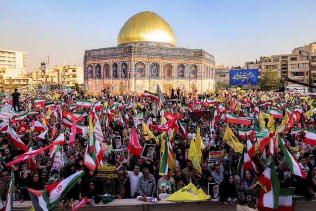 Demonstrators gather before a mockup of Jerusalem's Dome of the Rock Shrine during a rally in solidarity with the government against Israel's attacks on Iran and to mark Eid al-Ghadir, when according to Shiite Muslim belief the Islamic prophet Mohamed designated his nephew and companion Ali ibn Abi Talib as his successor, at Enghelab (Revolution) Square in Tehran on June 14, 2025. (Photo by Atta Kenare/AFP Photo)