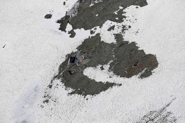 An aerial view of a science camp on the Olivares glacier next to the open pits of CODELCO'S Andina and Anglo American's Los Bronces copper mines (not pictured)  at Los Andes Mountain range, near Santiago city, November 17, 2014. (Photo by Ivan Alvarado/Reuters)