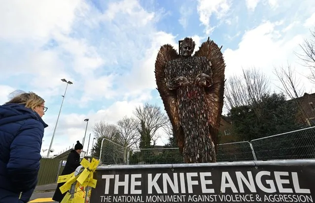 People view the Knife Angel sculpture, a National Monument Against Violence & Aggression, by artist Alfie Bradley and the British Ironworks Centre, in Slough, west of London on January 18, 2023. Created in order to highlight knife crime in the United Kingdom, the sculpture stands at just over eight meters tall, and is made from over 100,000 anonymously donated knives. (Photo by Justin Tallis/AFP Photo)
