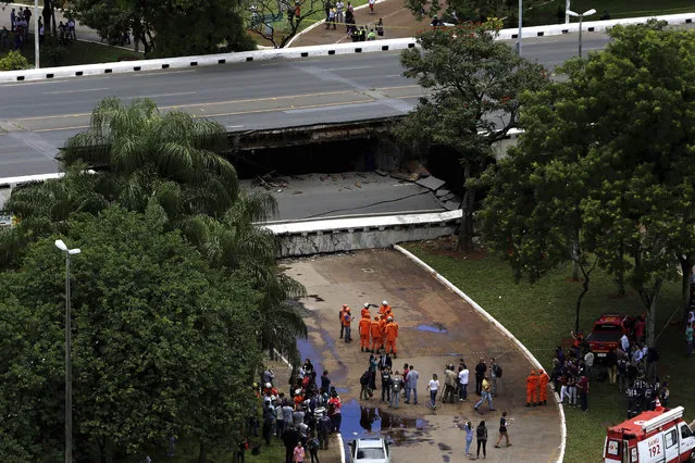 Emergency personnel work on an overpass that collapsed in the center of Brasilia, Brazil, Tuesday, February 6, 2018. The overpass collapsed destroying cars, part of a restaurant and snarling traffic in Brazil's capital. (Photo by Eraldo Peres/AP Photo)