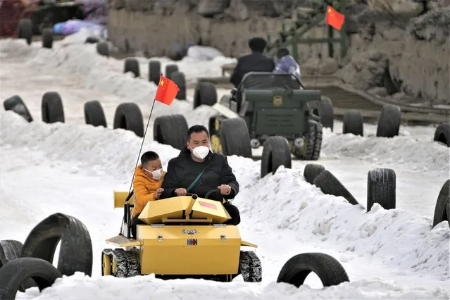 Residents ride on toy tanks in the snow at a public park in Beijing, Thursday, Januart 19, 2023. China on Thursday accused “some Western media” of bias, smears and political manipulation in their coverage of China's abrupt ending of its strict “zero-COVID” policy, as it issued a vigorous defense of actions taken to prepare for the change of strategy. (Photo by Andy Wong/AP Photo)