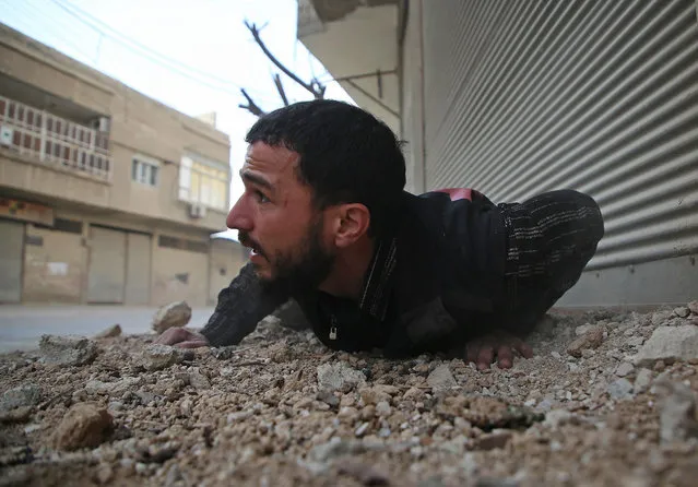 A Syrian man reacts following an air strike in the rebel-held enclave of Arbin in the  Eastern Ghouta near Damascus on February 8, 2018. (Photo by Amer Almohibany/AFP Photo)