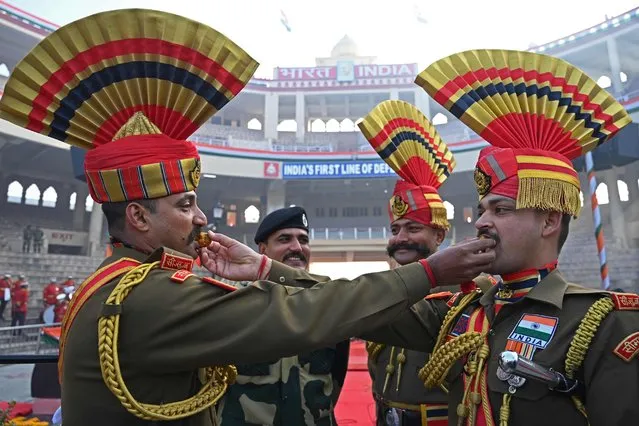 Indian Border Security Force (BSF) soldiers pose while offering sweets to each other during the celebrations to mark country's Republic Day at the India-Pakistan Wagah border post, about 35km from Amritsar on January 26, 2023. (Photo by Narinder Nanu/AFP Photo)