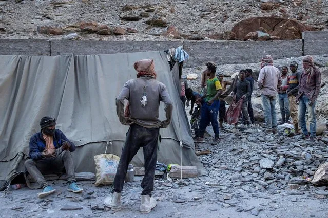 Workers from the Border Roads Organisation (BRO) clean themselves after arriving at their living quarters. They are working to construct a highway in the Ladakh region, India, September 17, 2020. Picture taken September 17, 2020. (Photo by Danish Siddiqui/Reuters)