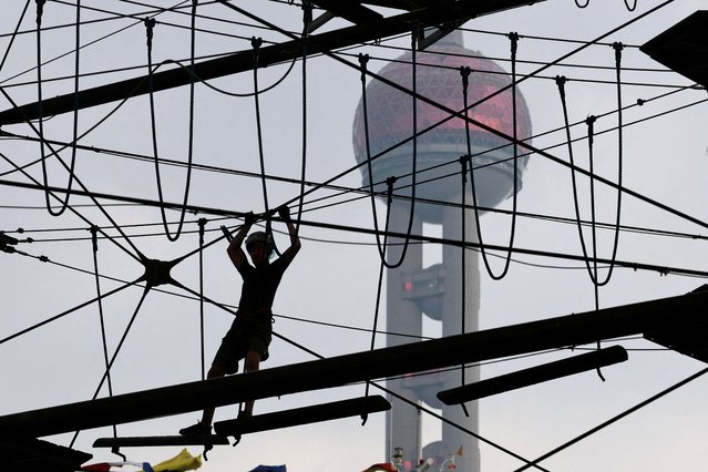 A person crosses a wire bridge at an athletic playground in Shanghai, China on July 10, 2025. (Photo by Go Nakamura/Reuters)