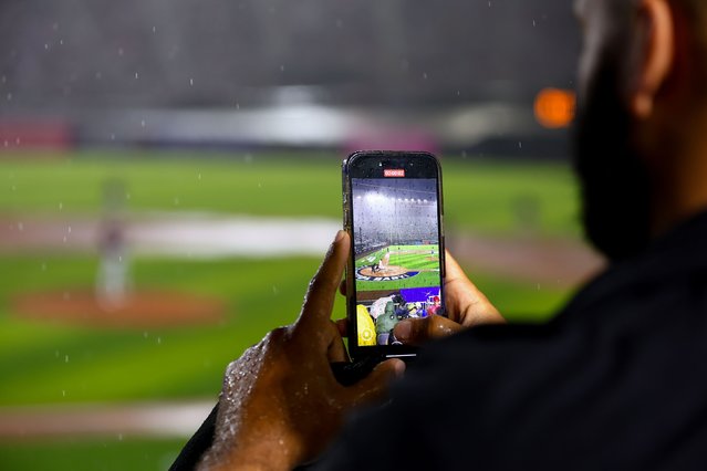 A fan takes a video on their phone in the first inning during the 2025 MLB Speedway Classic presented by BulidSubmarines.com between the Atlanta Braves and the Cincinnati Reds at Bristol Motor Speedway on Saturday, August 2, 2025 in Bristol, Tennessee. (Photo by Andrew Ferguson/MLB Photos via Getty Images)