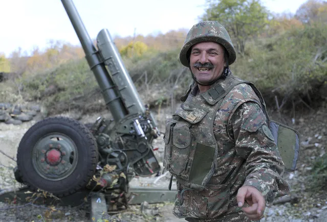 An ethnic Armenian soldier smiles as he speaks to journalists at a fighting position on the front line, during a military conflict against Azerbaijan's armed forces in the separatist region of Nagorno-Karabakh, Wednesday, October 21, 2020. Armenia's prime minister has urged citizens to sign up as military volunteers to help defend the country amid the conflict with Azerbaijan over the disputed territory of Nagorno-Karabakh as intense fighting has raged for a fourth week with no sign of abating. (Photo by Sipan Gyulumyan/Armenian Defense Ministry Press Office/PAN Photo via AP Photo)