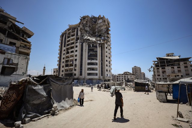 A general view of the buildings heavily damaged by Israeli attacks and the makeshift tents where Palestinians are trying to survive during a hot summer day in the Al-Katibeh area of Gaza City, Gaza on August 04, 2025. Displaced Palestinians, struggling to survive under harsh conditions due to rising temperatures, are experiencing great difficulty in accessing basic needs. The density of tents is increasing in the days when Israeli attacks continue. (Photo by Khames Alrefi/Anadolu via Getty Images)