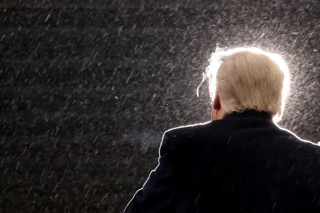 U.S. President Donald Trump holds a campaign event in the rain at Capital Region International Airport in Lansing, Michigan, U.S. October 27, 2020. (Photo by Jonathan Ernst/Reuters)