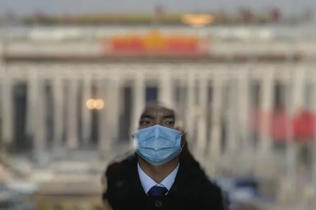 A soldier dressed as an usher stands guard at an entrance door of the Great Hall of the People in Beijing, Friday, March 3, 2023. The installation of new leaders and the need to shore up a flagging economy will dominate the annual session of China's rubber-stamp parliament that kicks off this Sunday. (Photo by Andy Wong/AP Photo)