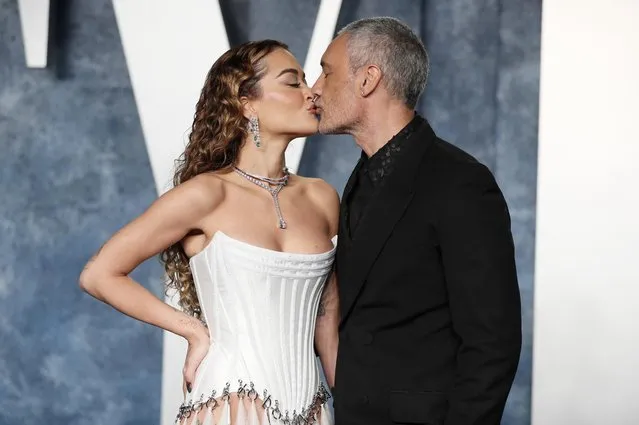 British singer-songwriter Rita Ora (l) and New Zealand filmmaker, actor and comedian Taika Waititi kiss during their arrival at the Vanity Fair Oscar party after the 95th Academy Awards, known as the Oscars, in Beverly Hills, California, U.S., March 12, 2023. (Photo by Danny Moloshok/Reuters)