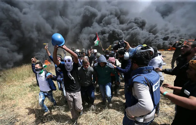 Palestinians evacuate mortally wounded Palestinian journalist Yasser Murtaja, 31, during clashes with Israeli troops at the Israel-Gaza border, in the southern Gaza Strip  April 6, 2018. (Photo by Ibraheem Abu Mustafa/Reuters)