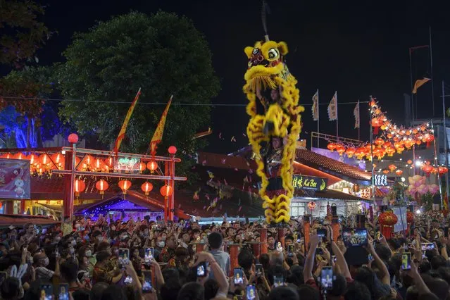 Revelers watch the high pole lion dance performance to celebrate Jade Emperor's Birthday Celebration, known as Thi-Kong Seh in Hokkien, in Weld Quay, Penang Malaysia, Sunday, January 29, 2023. (Photo by Vincent Thian/AP Photo)