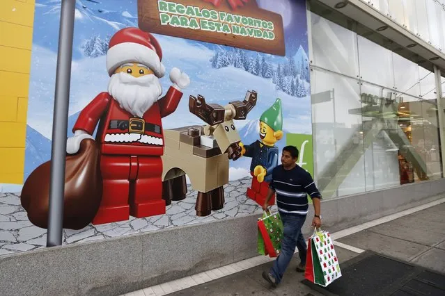 A man walks past a window display of Lego for Christmas at a Saga Falabella department store in the Miraflores district of Lima, December 23, 2014. (Photo by Mariana Bazo/Reuters)