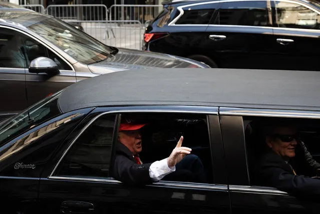 A Trump impersonator drives by Trump Tower in New York, NY on Tuesday, April 4, 2023, as crowds await the departure of former president Donald Trump. Trump became the first sitting or former U.S. president to be indicted and plans to turn himself in Tuesday and then appear in court in New York to be arraigned in a case that involves payoffs through an intermediary to adult-film actress Stormy Daniels to conceal an alleged affair ahead of the 2016 election. (Photo by Joe Lamberti for The Washington Post)