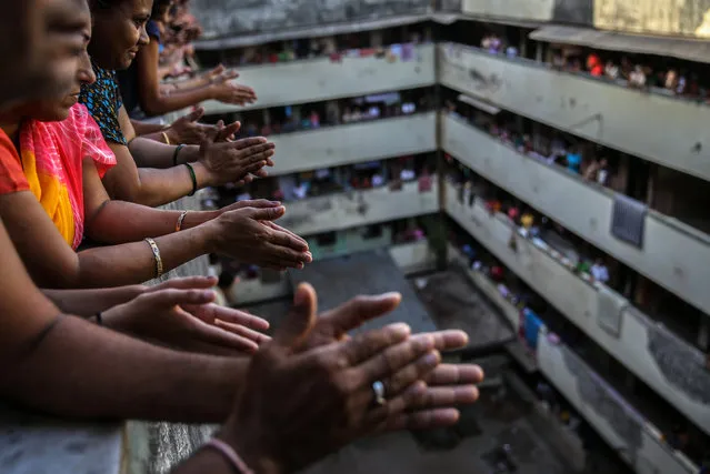 Indian people bang utensils and clap from the balconies of a residential building in Mumbai, India, 22 March 2020. Prime Minister Narendra Modi asks citizens to impose self-curfew to fight Coronavirus COVID-19 and also ask them to clap, bang the bells and utensils at 5pm Indian time to mark of respect and to thank the medical staff and others working 24 hours, during Covid-19 outbreak to keeping the Indians safe. (Photo by Divyakant Solanki/EPA/EFE)