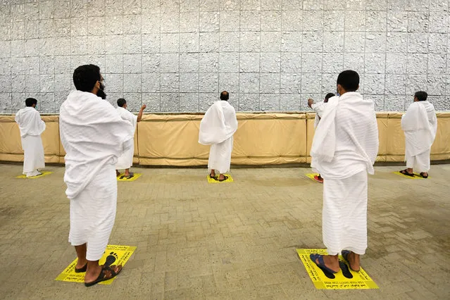 Muslim pilgrims cast stones at a pillar in the symbolic stoning of the devil, the last rite of the annual hajj, and the first day of Eid al-Adha, in Mina near the holy city of Mecca, Saudi Arabia, Friday, July 31, 2020. The global coronavirus pandemic has cast a shadow over every aspect of this year's pilgrimage, which last year drew 2.5 million Muslims from across the world to Mount Arafat, where the Prophet Muhammad delivered his final sermon nearly 1,400 years ago. Only a very limited number of pilgrims were allowed to take part in the hajj amid numerous restrictions to limit the potential spread of the coronavirus. (Photo by Saudi Ministry of Media via AFP Photo)