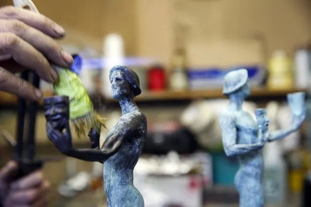 Patina artist Joaquin Quintero applies a formula of salts and acids on the bronze metal in order to create the patina coloring on “The Actor” statuette during a media event on the production of statuettes for the 21th annual Screen Actors Guild (SAG) Awards at American Fine Arts Foundry in Burbank, California January 13, 2015. (Photo by Patrick T. Fallon/Reuters)